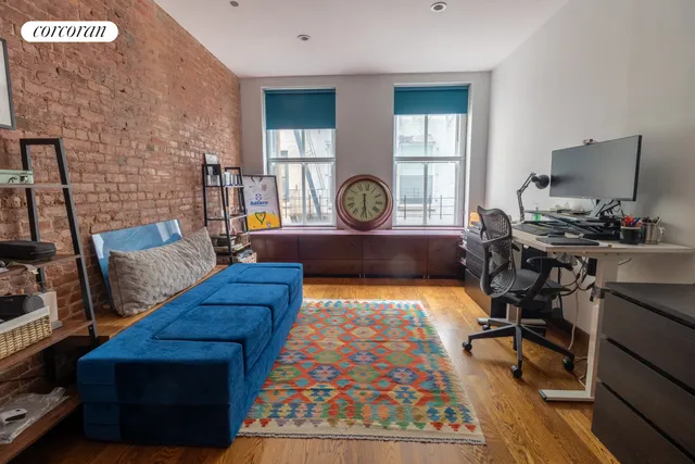 a bedroom with a bed a dresser next to a window