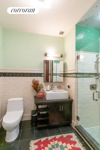 a bathroom with a tub shower sink and mirror