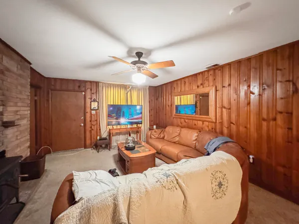 a living room with furniture a ceiling fan and a rug