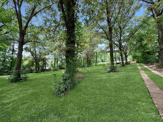 a view of a house with a yard and sitting area