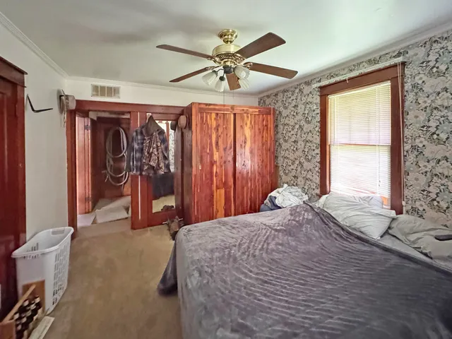 a bedroom with a bed dresser and a window
