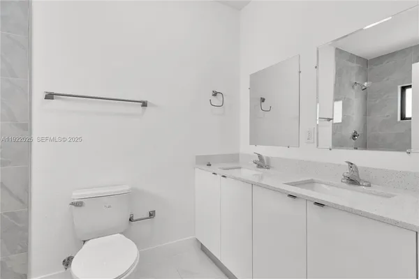 a bathroom with a granite countertop sink mirror and toilet