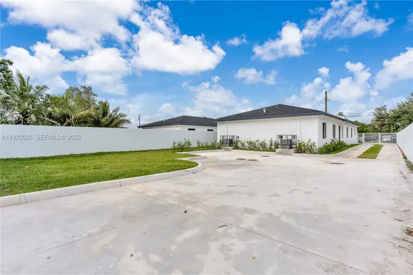 a view of a house with a yard and large tree