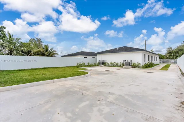 a view of a house with a yard and large tree