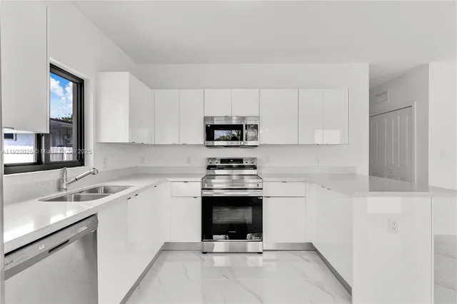 a kitchen with a sink cabinets and stainless steel appliances
