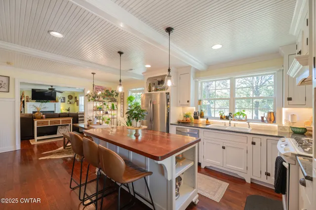 a kitchen with granite countertop a sink appliances and cabinets