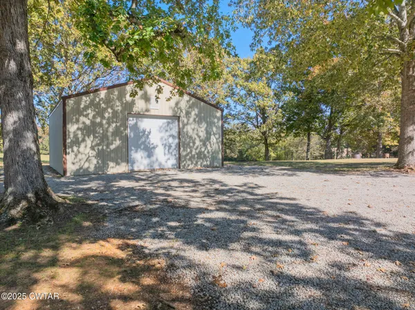 a view of dirt yard with a large tree