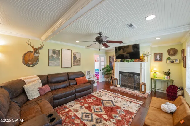 a living room with furniture a flat screen tv and a fireplace