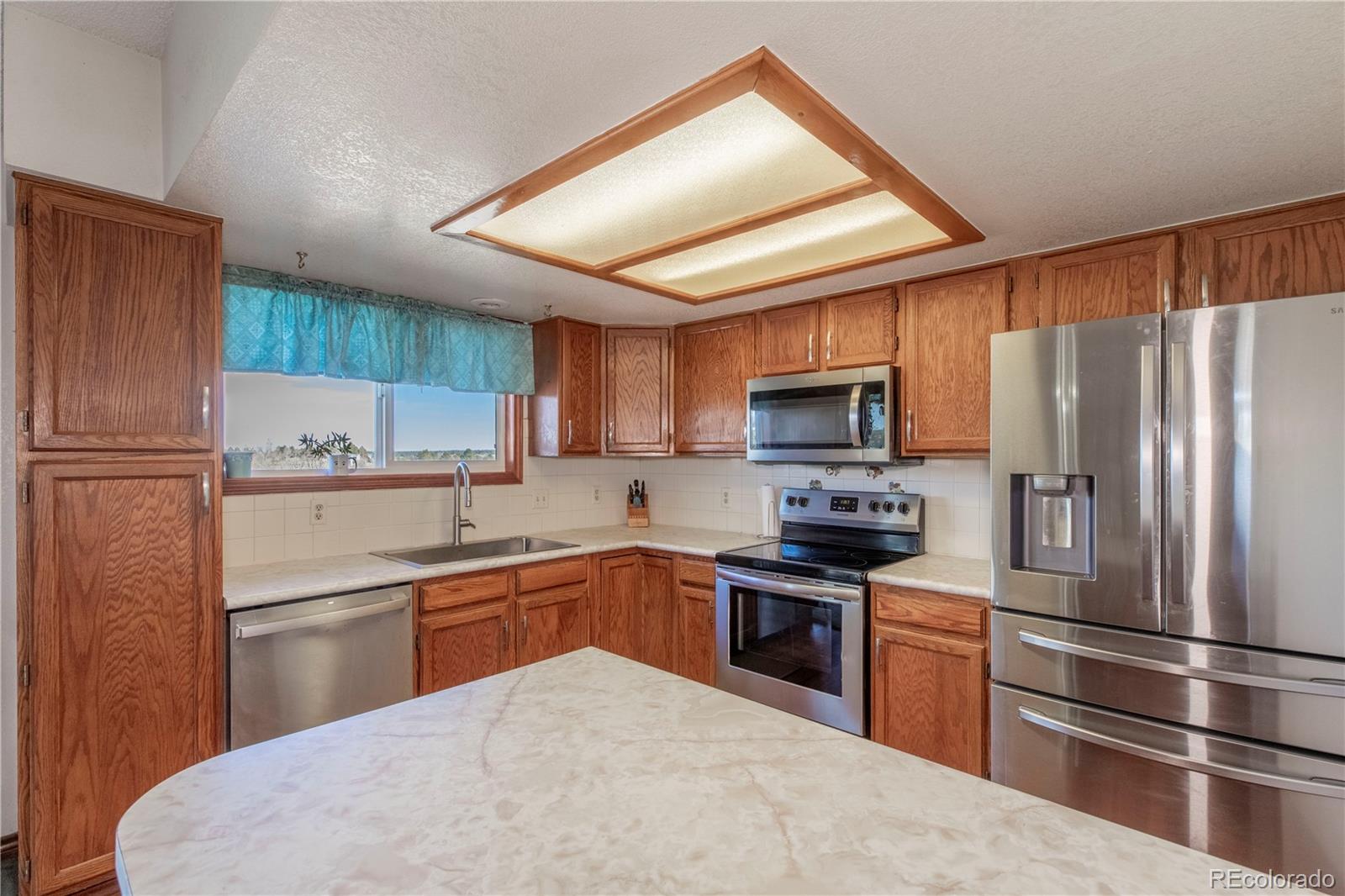 2141 Remington Road Elizabeth, CO 80107 - Photo 8 of 42 a kitchen with granite countertop stainless steel appliances and wooden cabinets