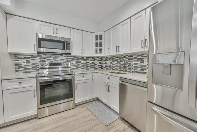 a view of a dining room with furniture a chandelier and wooden floor