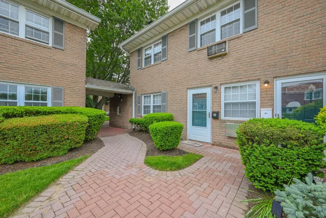 a front view of a house with garden and lots of green space