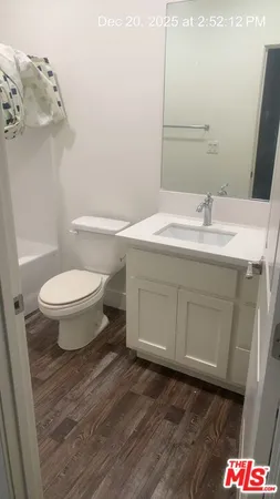 a bathroom with a granite countertop sink toilet and mirror