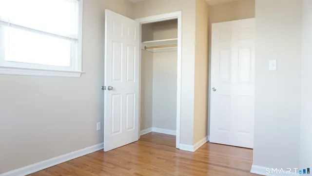 an empty room with wooden floor and a window