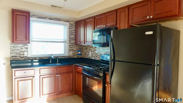 a kitchen with stainless steel appliances granite countertop a refrigerator and a sink