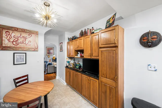 a kitchen with stainless steel appliances granite countertop a refrigerator a stove a sink dishwasher and a dining table with wooden floor