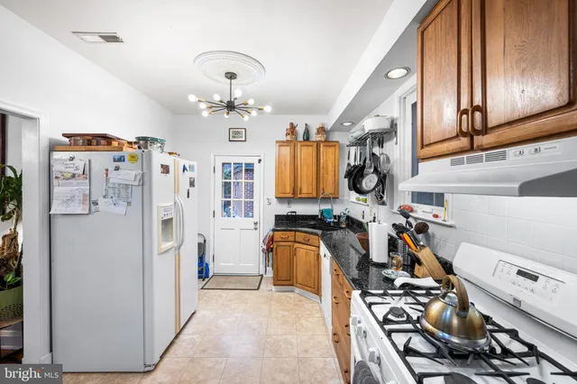 a view of a kitchen with fridge and workspace