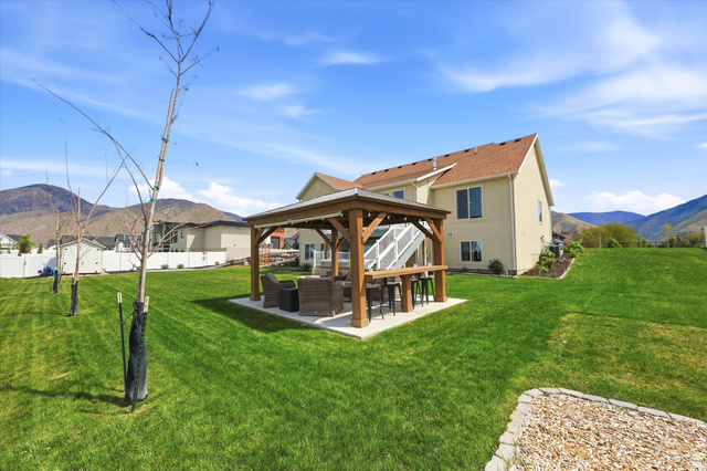 283 North 500 West Mapleton, UT 84664 - Photo 82 of 102 Back of property featuring a mountain view, a patio, an outdoor hangout area, a gazebo with a bar.