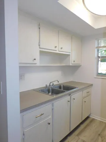 a kitchen with white cabinets and a sink
