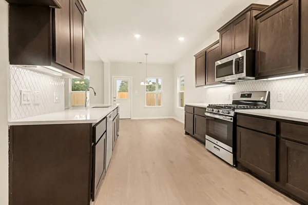 a kitchen with stainless steel appliances granite countertop a stove and a refrigerator