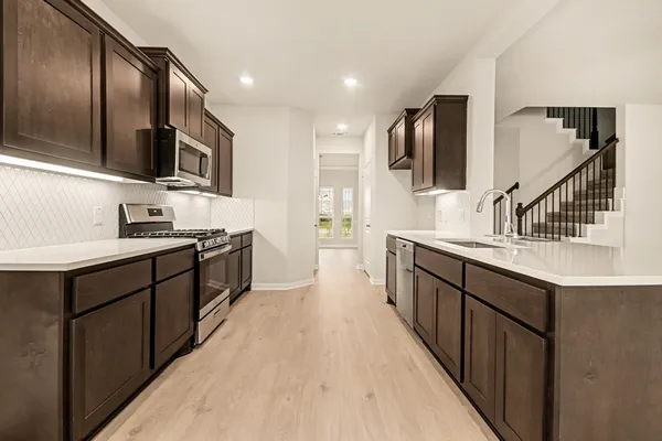 a large kitchen with stainless steel appliances kitchen island granite countertop a sink and cabinets