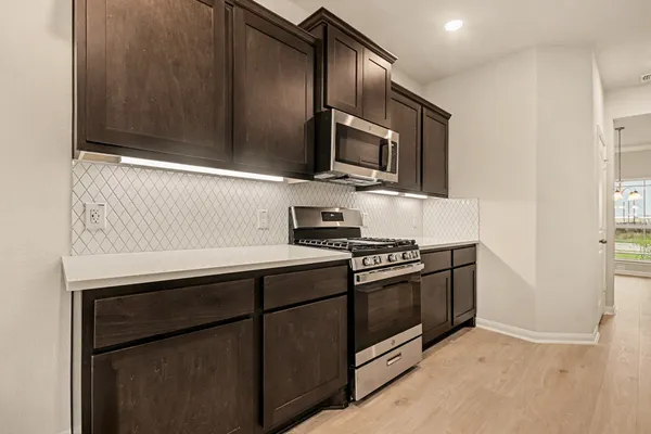 a kitchen with stainless steel appliances and granite countertop white cabinets