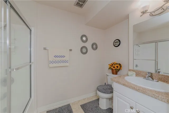 a bathroom with a granite countertop sink a toilet and a mirror