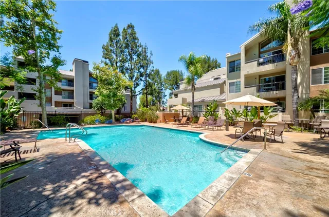a view of swimming pool with lawn chairs and plants