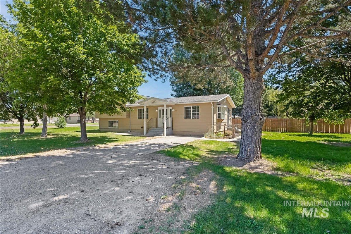1940 Q Street Heyburn, ID 83336 - Photo 1 of 30 Single-story residence featuring a covered front porch with white railings, a light beige exterior, and a gravel driveway