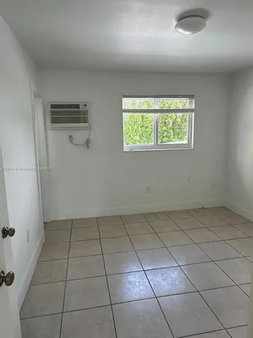 an empty room with white walls and tiles