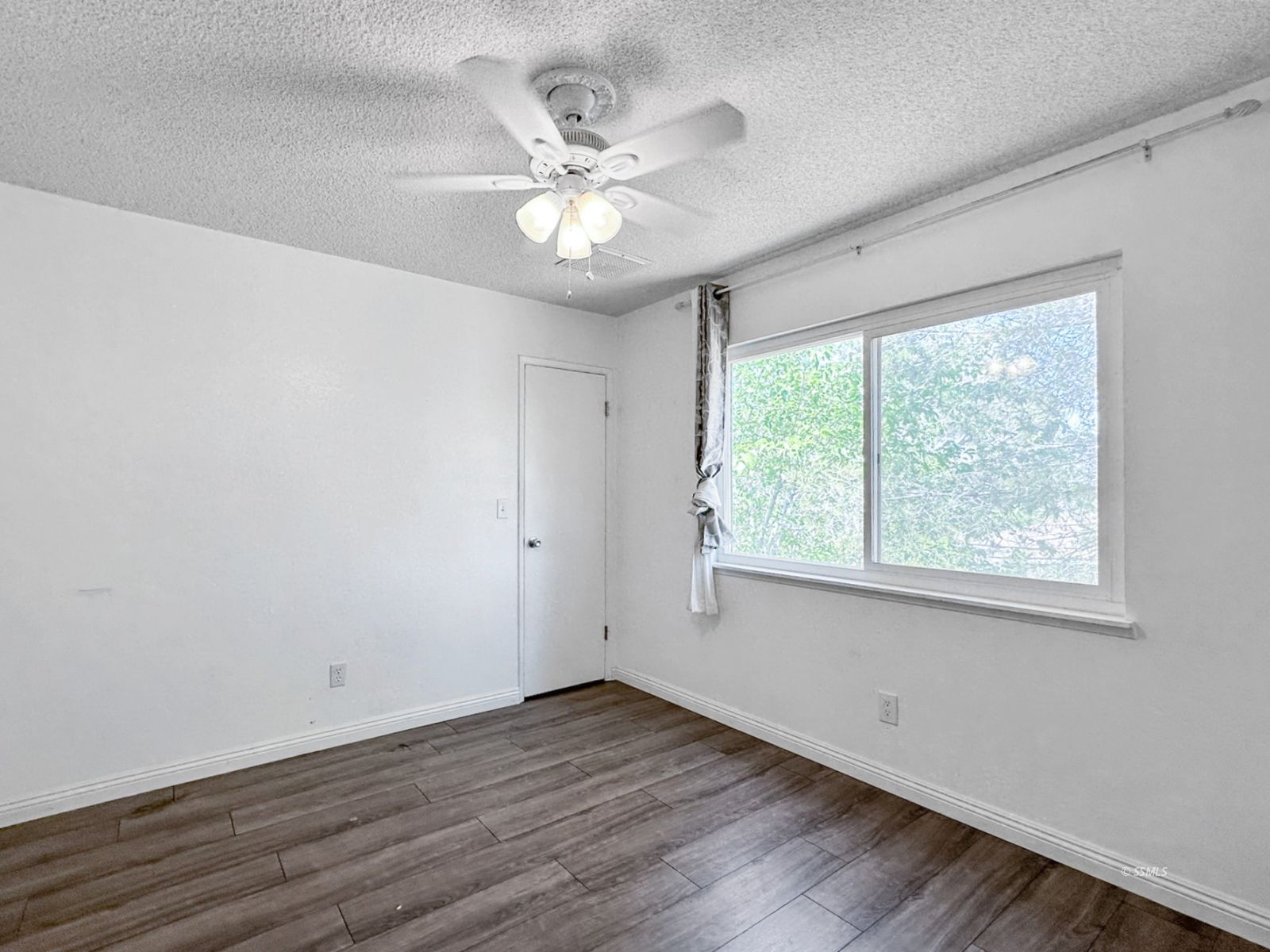 724 West Dolphin Avenue Ridgecrest, CA 93555 - Photo 28 of 50 a view of an empty room with wooden floor and a window