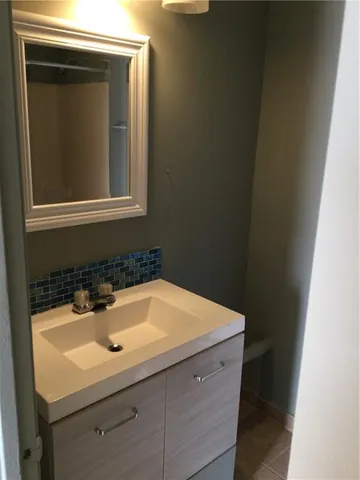 a sink sitting under a bathroom mirror