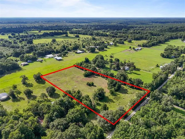 an aerial view of residential houses with outdoor space and river
