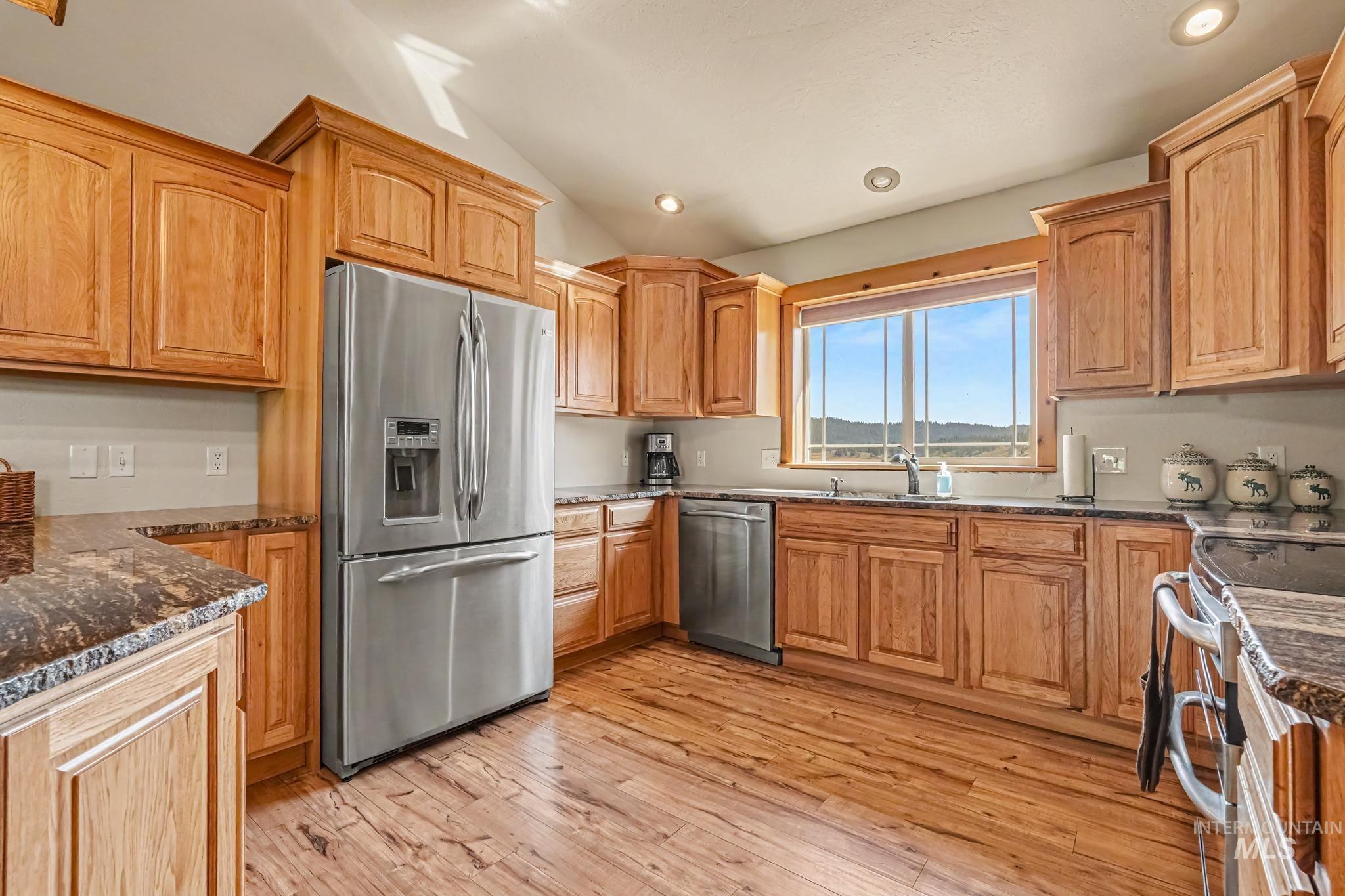 106 Wilderness Lake Road Cascade, ID 83611 - Photo 15 of 35 Kitchen featuring wood-finish flooring, natural wood cabinetry, dark stone countertops, stainless steel appliances, and recessed lighting