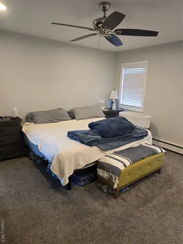 a bedroom with a bed and a ceiling fan