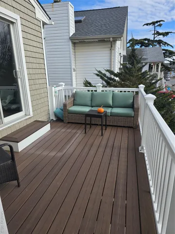 a view of a patio with couches chairs and wooden floor
