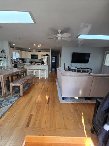 a living room with stainless steel appliances furniture and a kitchen view