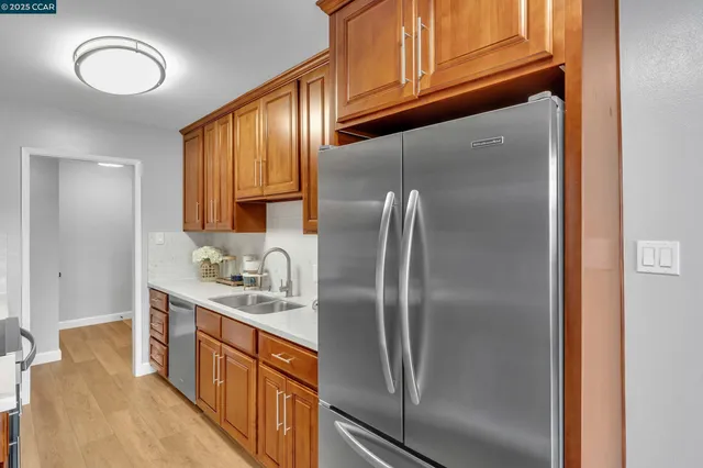 a kitchen that has a lot of cabinets stainless steel appliances and a counter top space