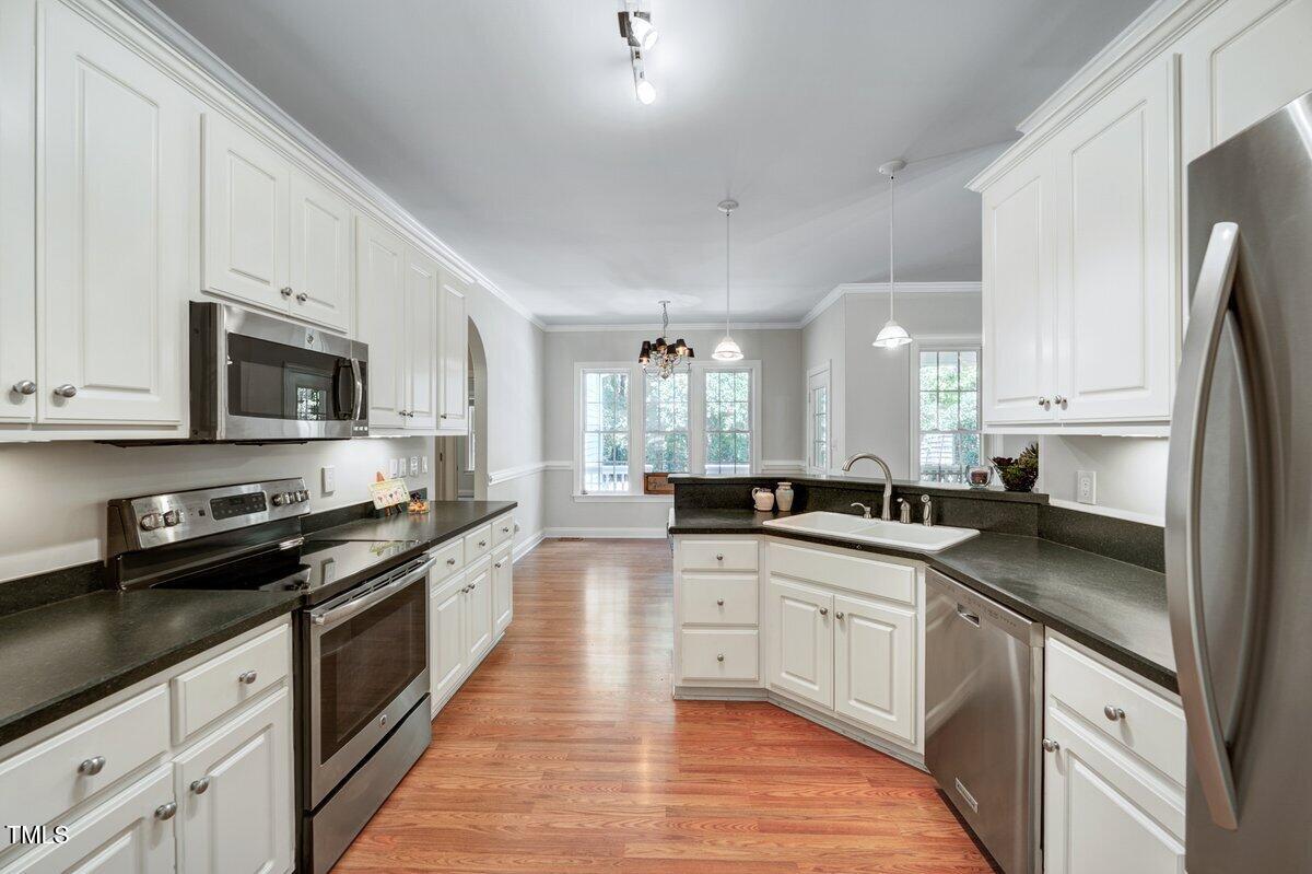 1321 Taylor Farm Road Raleigh, NC 27603 - Photo 14 of 41 a large kitchen with stainless steel appliances granite countertop a lot of counter space and wooden cabinets