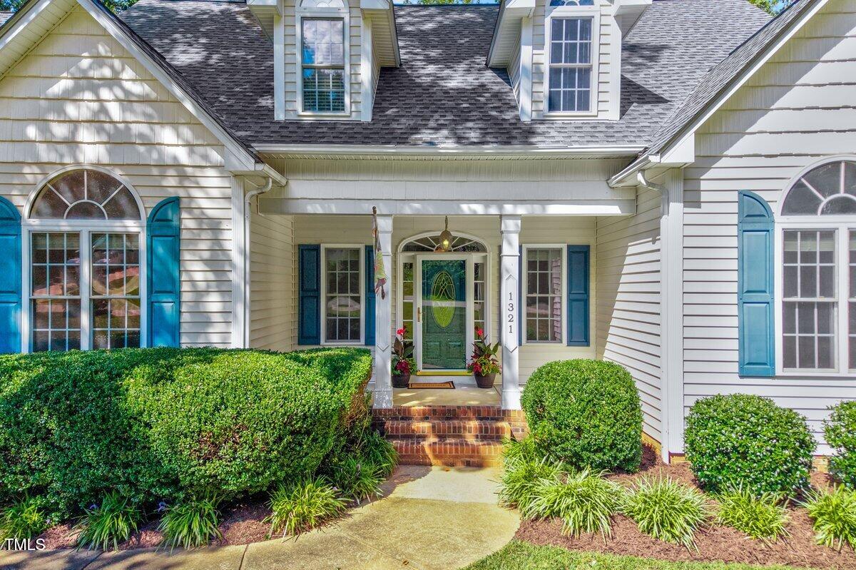 1321 Taylor Farm Road Raleigh, NC 27603 - Photo 3 of 41 front view of a brick house with a large window and potted plants