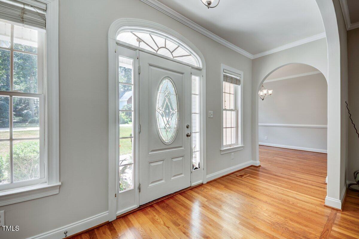 1321 Taylor Farm Road Raleigh, NC 27603 - Photo 6 of 41 an empty room with wooden floor mirror and windows