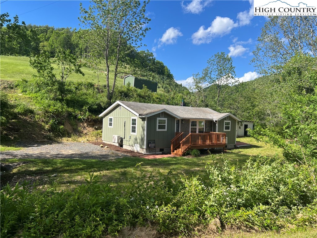 9635 Highway 194 Lansing, NC 28643 - Photo 2 of 28 a house that is sitting in the grass with large trees and plants