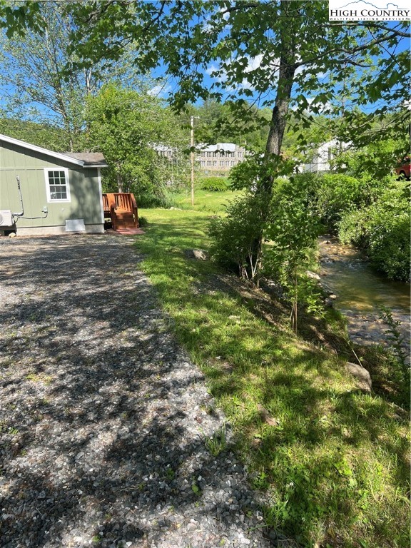 9635 Highway 194 Lansing, NC 28643 - Photo 8 of 28 a view of a yard with plants and a bench