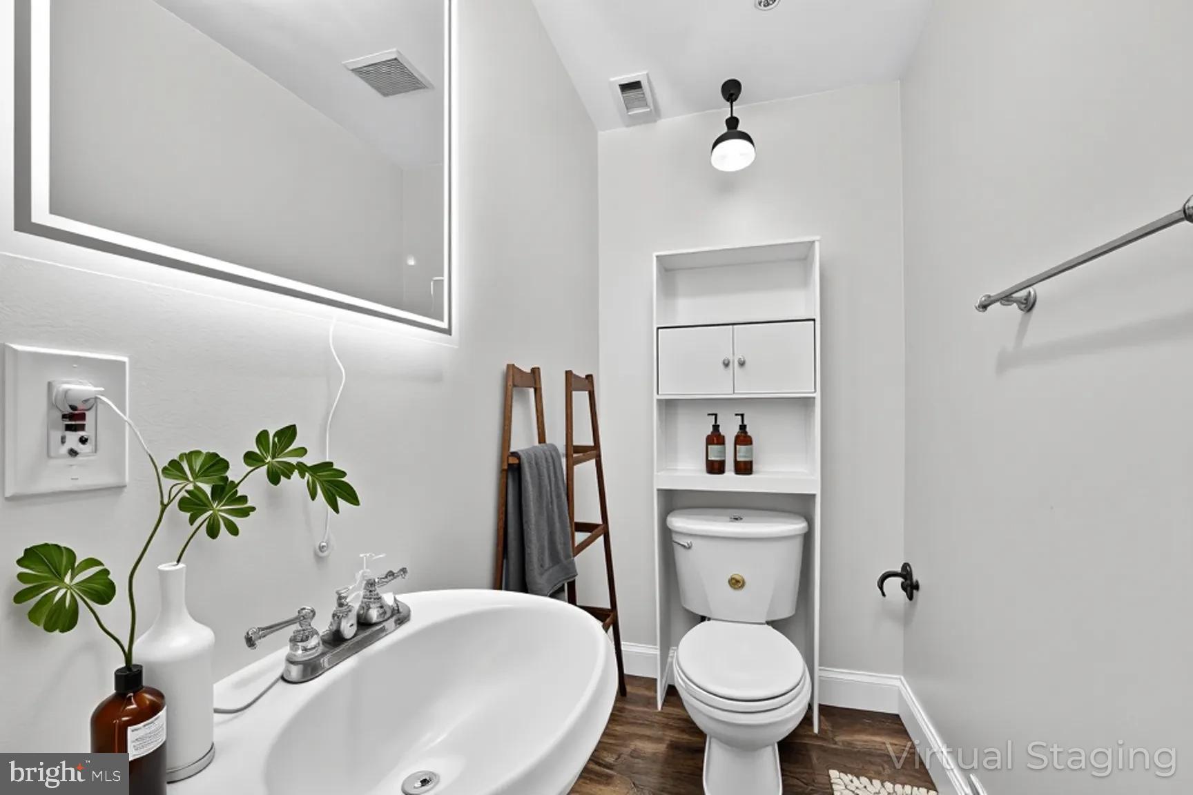 1251 I Street Northeast Washington, DC 20002 - Photo 13 of 31 a bathroom with a toilet a sink and mirror