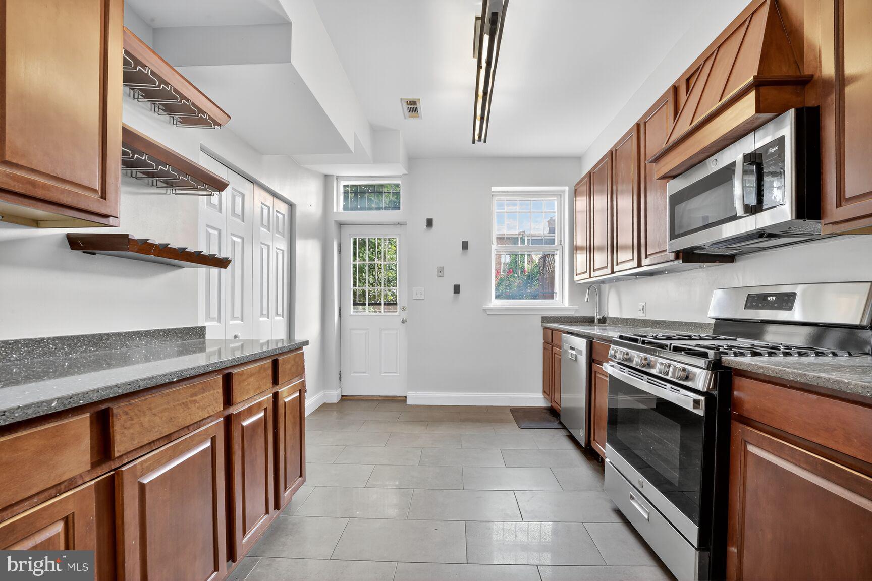 1251 I Street Northeast Washington, DC 20002 - Photo 17 of 31 a kitchen with stainless steel appliances granite countertop a stove and a sink