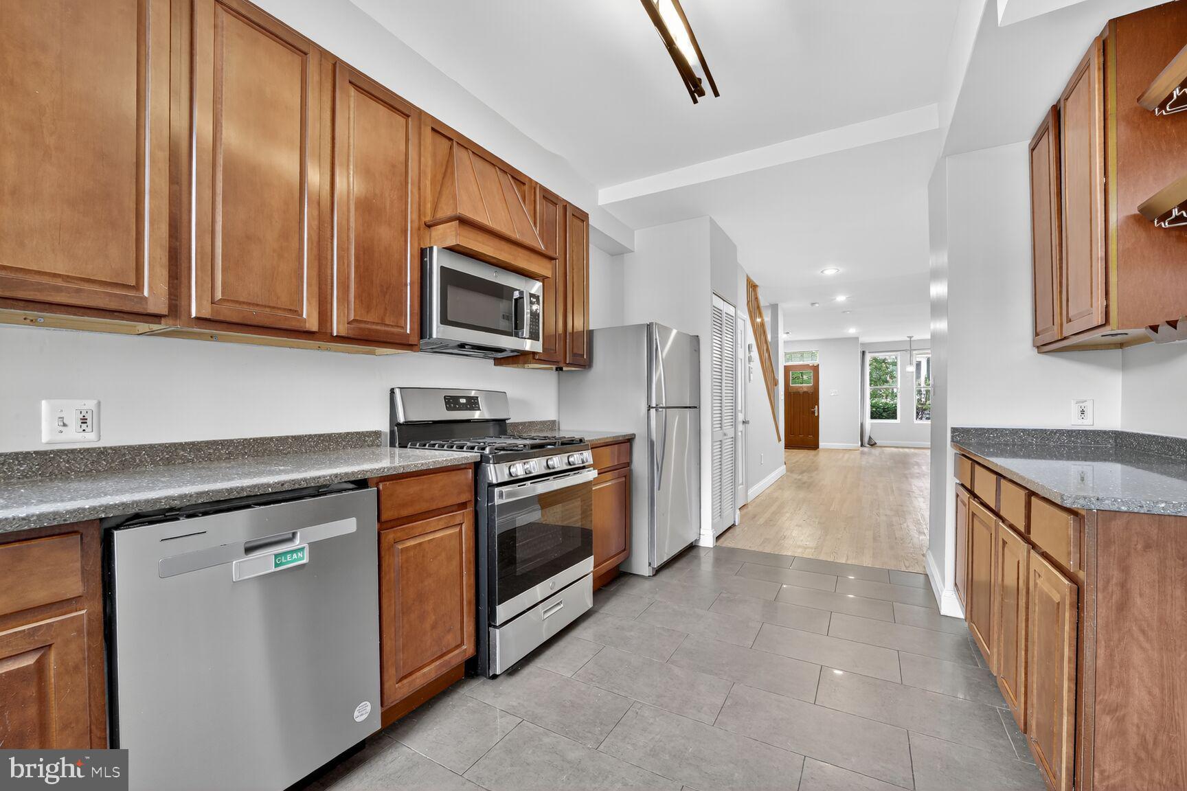 1251 I Street Northeast Washington, DC 20002 - Photo 19 of 31 a kitchen with stainless steel appliances granite countertop a stove a sink and a microwave