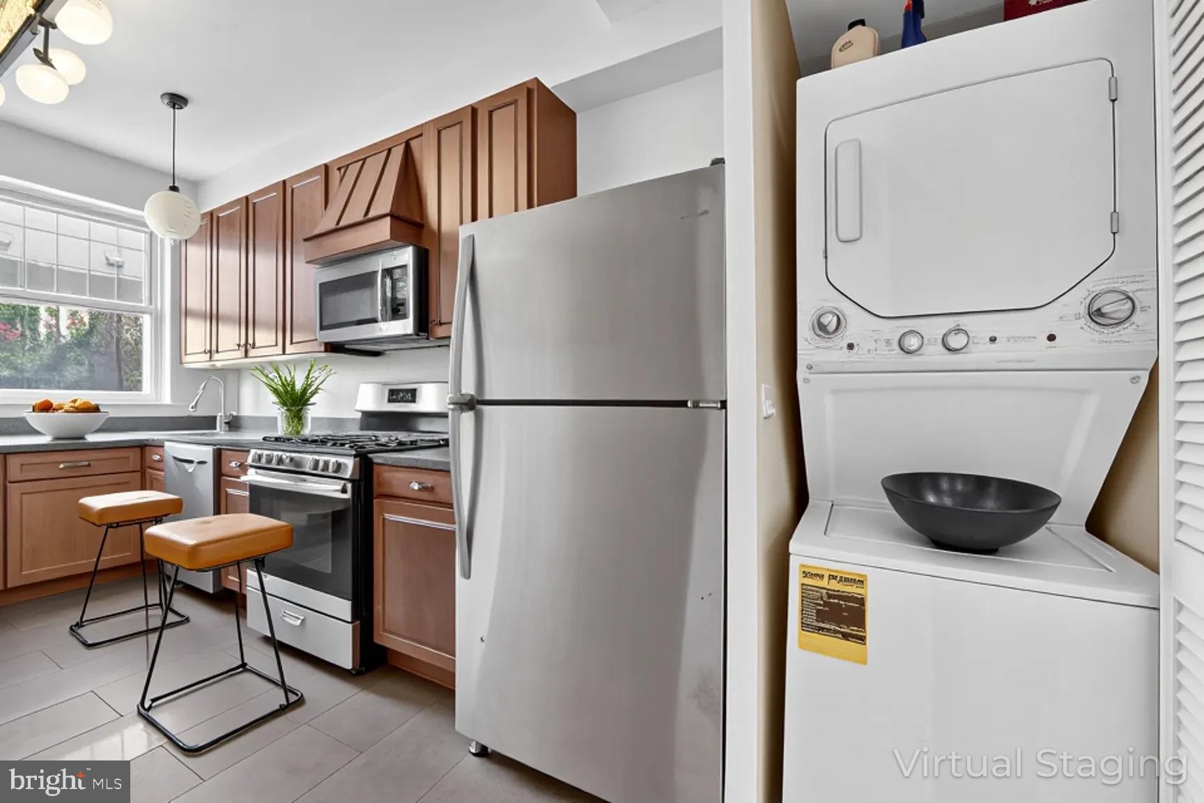 1251 I Street Northeast Washington, DC 20002 - Photo 7 of 31 a kitchen with a refrigerator a stove a microwave a dining table and chairs