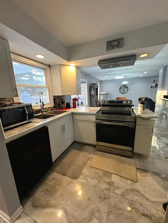 a kitchen with stainless steel appliances kitchen island granite countertop a sink and cabinets