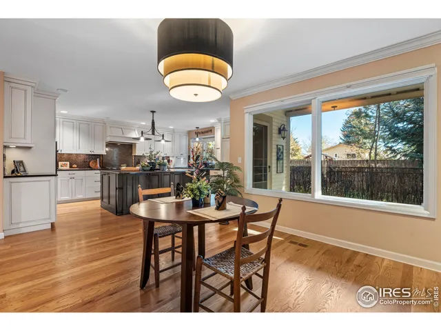 a kitchen with stainless steel appliances kitchen island granite countertop a table and chairs in it