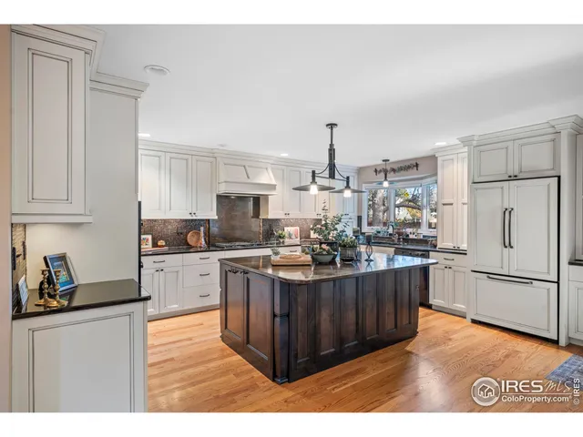 a kitchen with stainless steel appliances kitchen island granite countertop a refrigerator a stove and a sink