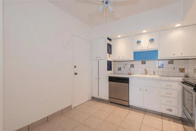 a kitchen with a refrigerator and a stove top oven
